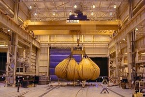 This 200/50 ton radio-controlled crane loads turbines onto rail cars for shipment. Crane has a span of 75 feet, a lift of 40 feet, and uses two SEN Crane engineered hoists