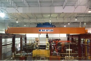 A double box girder crane features a 50 ton main hook and 20 ton auxiliary to maneuver large molds at a Midwestern automotive plastics plant. A 350 foot runway was designed, manufactured an installed by SEN Crane. Crane and runway are completely freestanding